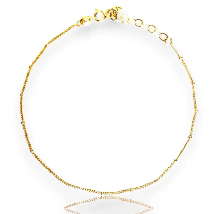 A gold-filled satellite anklet with adjustable clasp and sparkling beads.