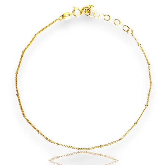 A gold-filled satellite anklet with adjustable clasp and sparkling beads.