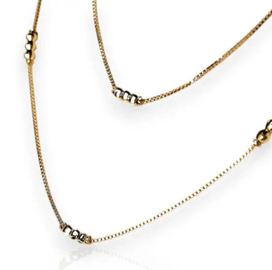 Gold necklace with small beads on a white background