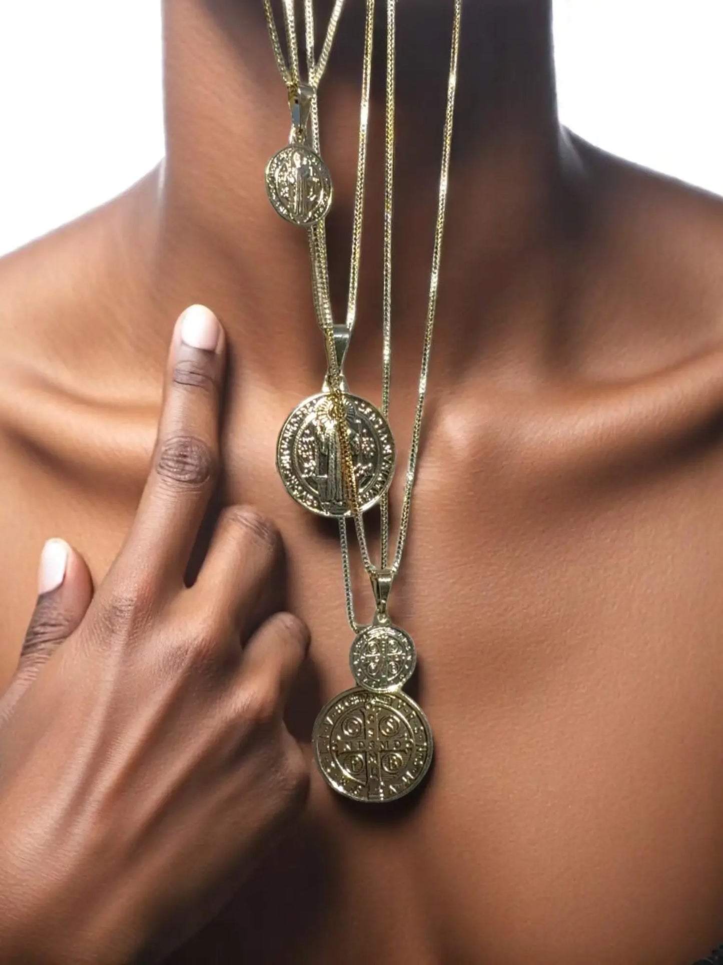 Gold necklace with circular pendants on a person's neck