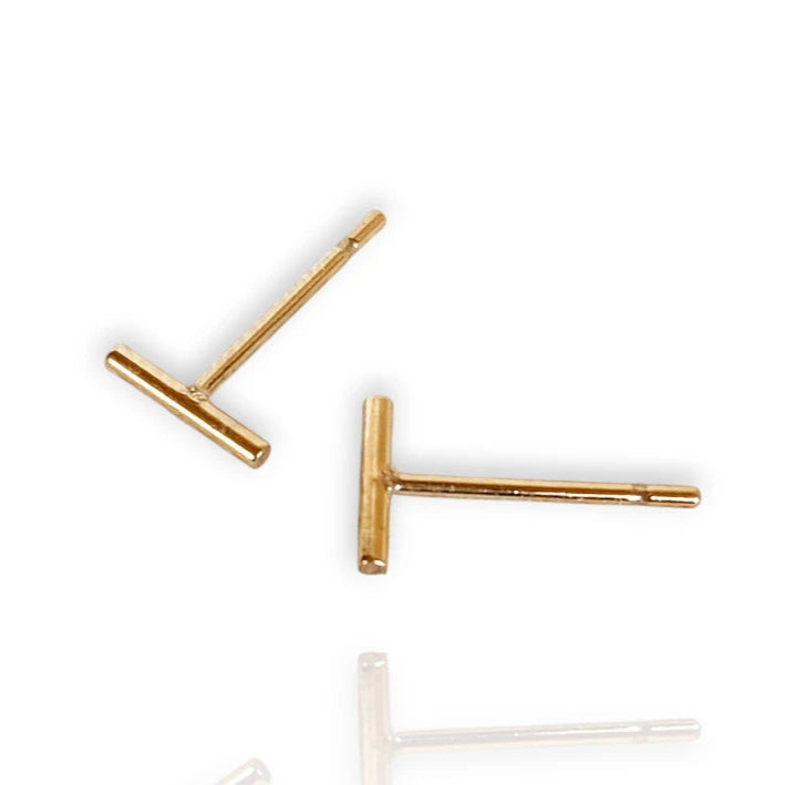 A pair of 14k gold filled petite bar stud earrings with a minimalist design on a white background