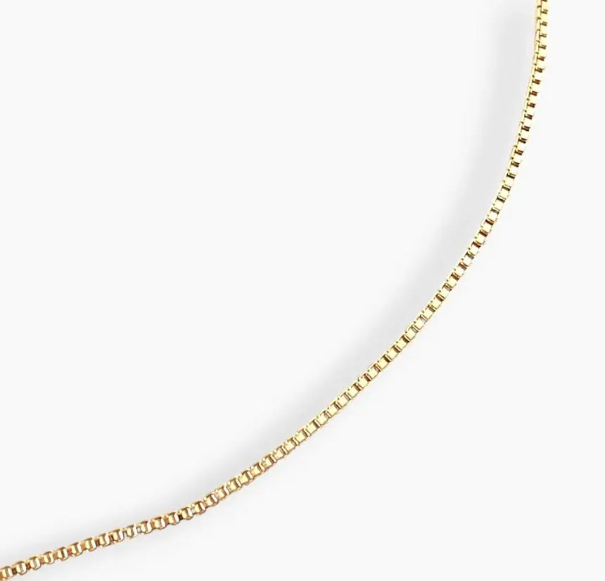 close up of gold-filled box chain bracelet on white background