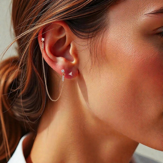 Close-up of a person wearing diamond earrings with a blurred background