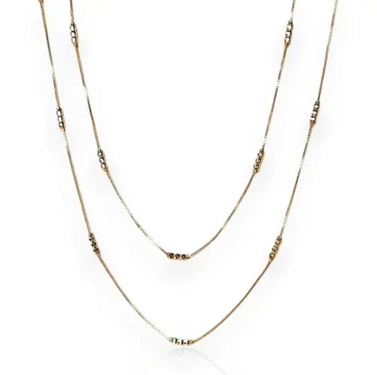 Two gold necklaces on a white background