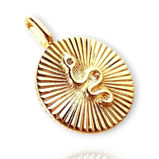 A gold-colored circular pendant necklace with a coiled snake design in the center, displayed against a white background. with a cubic zirconia on snakes head