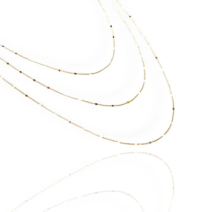 A gold curb chain necklace with a sleek, modern design, displayed against a white background.