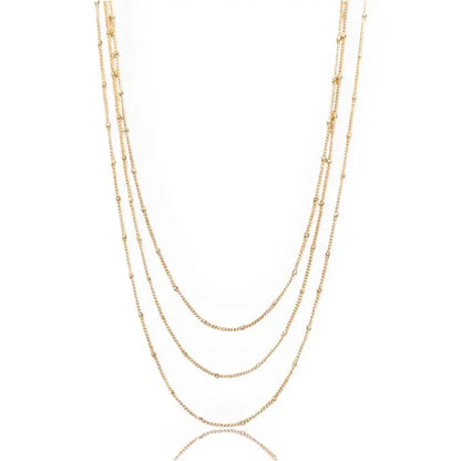 Gold necklace with multiple lengeths on a white background