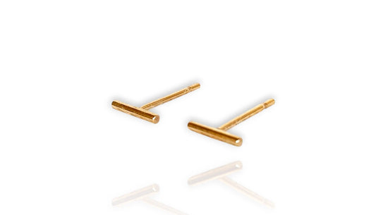 A pair of 14k gold filled petite bar stud earrings with a minimalist design on a white background 