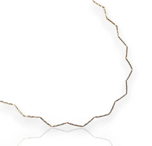 A gold-filled chain necklace with a zigzag design, displayed against a white background.